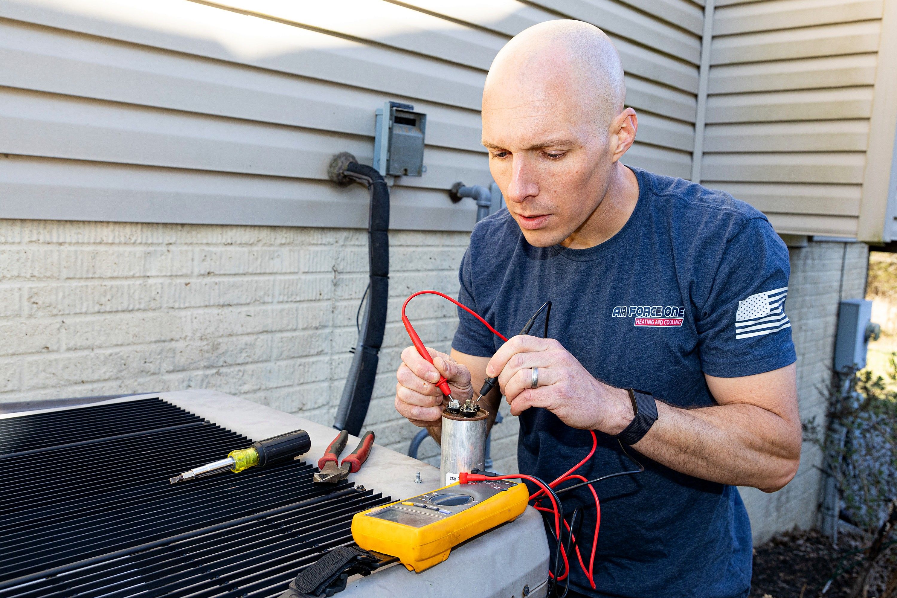 Jim Higgins testing the capacitor on an outdoor heat pump unit