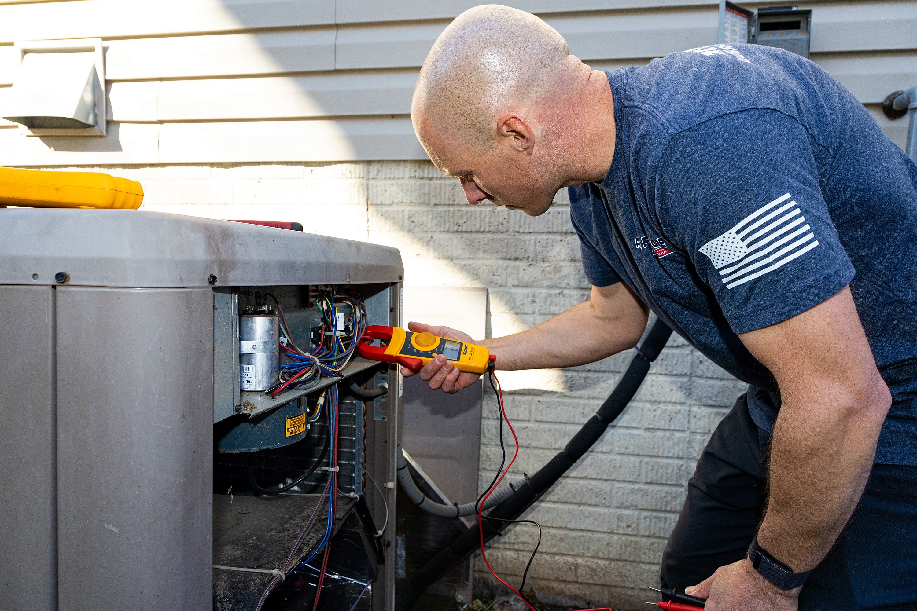 Jim Higgins diagnosing an outdoor air conditioning unit with a meter in Northern Virginia