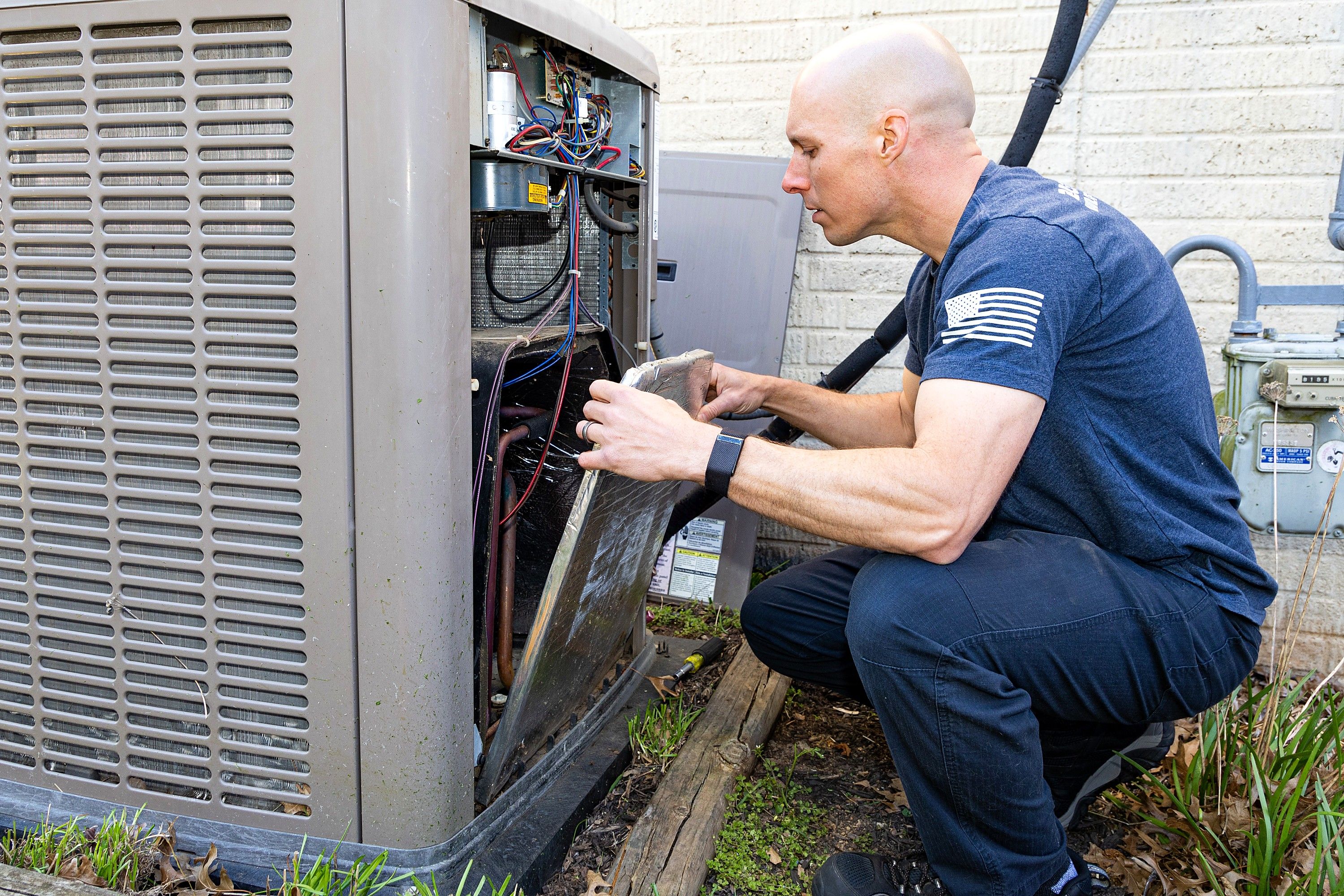 Jim Higgins servicing an outdoor HVAC unit during a maintenance visit